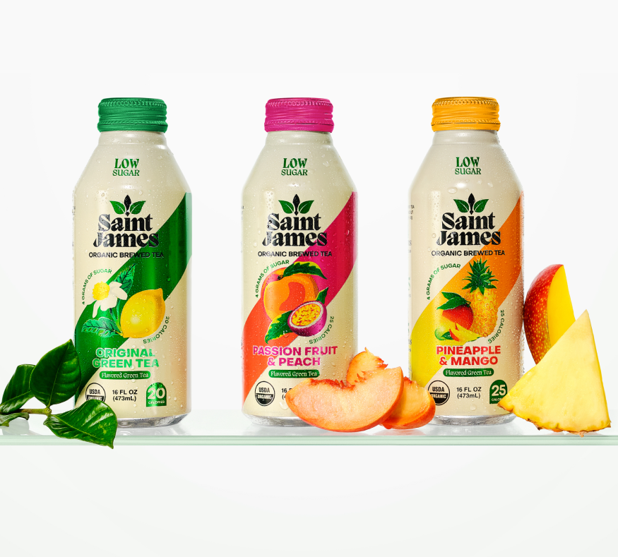 Saint James organic green tea, passion fruit and peach, and pineapple mango lined up with fruits beside
